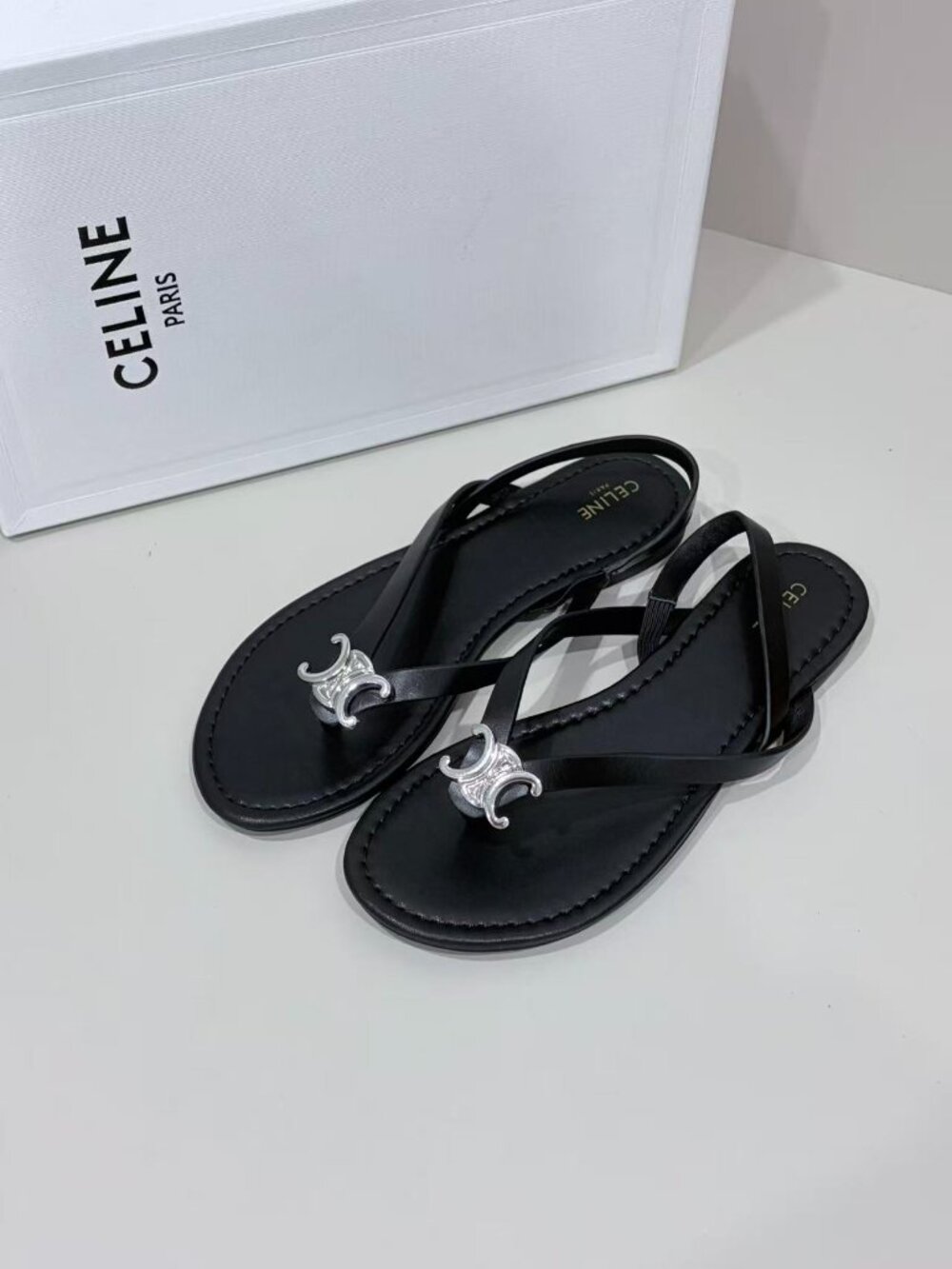 Celine Black‑Leather Silver‑Triomphe‑Ornament Ankle‑Strap Thong Flat Sandals